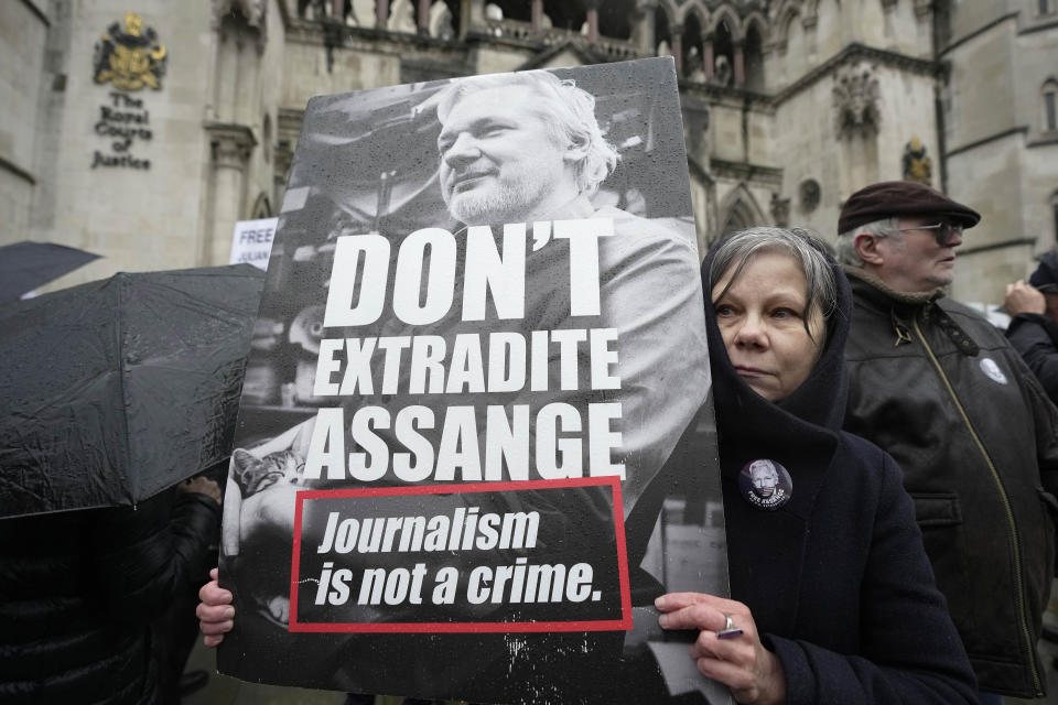 A protester holds a placard outside the Royal Courts of Justice in London, Wednesday, Feb. 21, 2024. Julian Assange's lawyers are on their final U.K. legal challenge to stop the WikiLeaks founder from being sent to the United States to face spying charges. The 52-year-old has been fighting extradition for more than a decade, including seven years in self-exile in the Ecuadorian Embassy in London and the last five years in a high-security prison. (AP Photo/Kin Cheung)