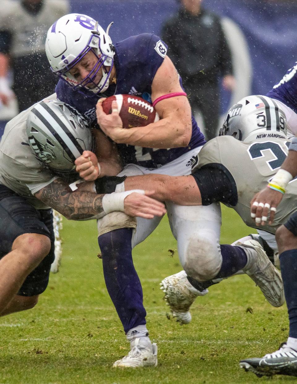 Holy Cross running back Peter Oliver crashes through the UNH defense in the third quarter Saturday, December 3, 2022.