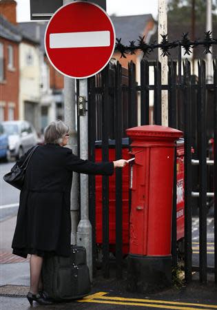 A woman posts a letter in Loughborough, central England, September 12, 2013. REUTERS/Darren Staples