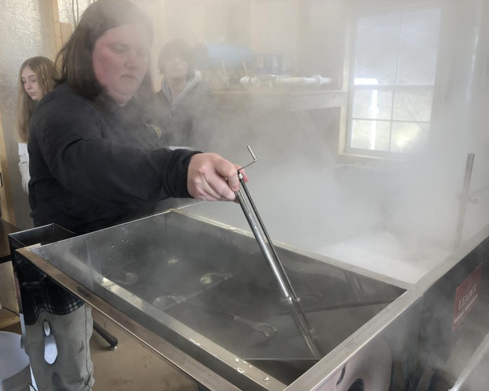 Marcus Whitman agriculture teacher Mary Coolbaugh tests the evaporator used to boil down sap for syrup.