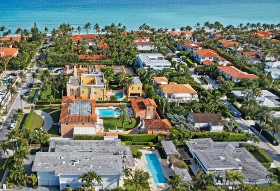With gray roofs, two side-by-side houses, foreground, at 150 Dunbar Road and 151 Atlantic Ave. are being marketed as a compound for $31.85 million in Palm Beach.