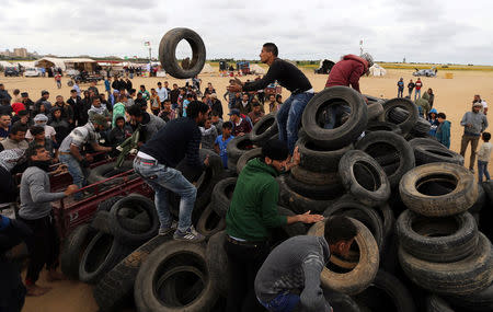 Palestinian activists collect tyres to be burnt along Israel-Gaza border, in the southern Gaza Strip April 3, 2018. REUTERS/Ibraheem Abu Mustafa