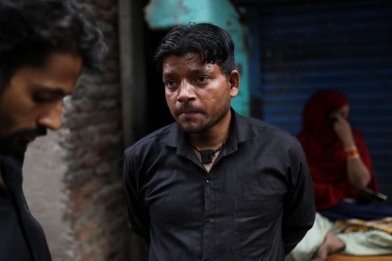 Mohammed Akbar, whose shop was razed during Wednesday's demolition drive of illegal encroachments, speaks with a person at an alley, in Jahangirpuri