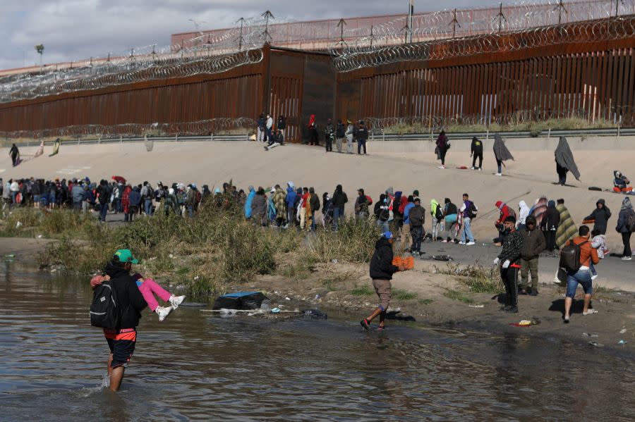 TOPSHOT – Migrants walk across the Rio Grande to surrender to US Border Patrol agents in El Paso, Texas, as seen from Ciudad Juarez, Chihuahua state, Mexico, on December 13, 2022. (Photo by Herika Martinez / AFP) (Photo by HERIKA MARTINEZ/AFP via Getty Images)