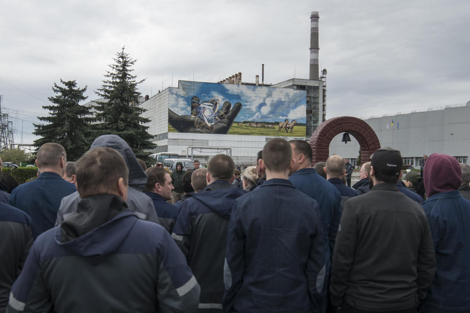 Chernobyl's nuclear power plant workers attend a memorial ceremony for the victims of the Chernobyl tragedy in Chernobyl, Ukraine, Wednesday, April 26, 2023. Ukrainian President Volodymyr Zelenskyy on Wednesday used the 37th anniversary of the world’s worst nuclear disaster to repeat his warnings about the potential threat of a new atomic catastrophe in Ukraine amid his country's war with Russia. (AP Photo/Wladyslaw Musiienko)