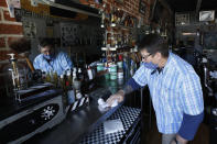 Mike Douglass, owner of the East J Barbershop, sanitizes the counters of his shop in Sacramento, Calif., Wednesday, May 27, 2020. Barbershops and hair salons in the Sacramento area and most other California counties can begin reopening following Gov. Gavin Newsom's announcement Tuesday. Douglass said he will reopen in a few days so he has time to get his shop ready to adhere to the new guidelines that must be followed due to the coronavirus pandemic. (AP Photo/Rich Pedroncelli)