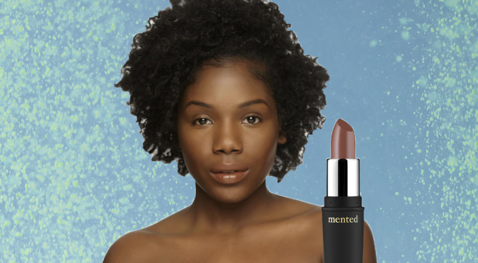 Black woman wearing her perfect neutral lipstick shade and that lipstick tube shown nearby.