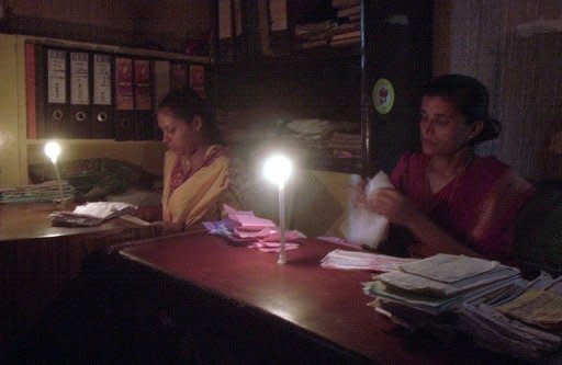 File photo shows office staff working by candlelight during a power cut in New Delhi. Industry leaders say electricity shortages have become a major obstacle to economic growth in the country, which has an installed power generation capacity of 187 gigawatts -- about 20 percent of China's level