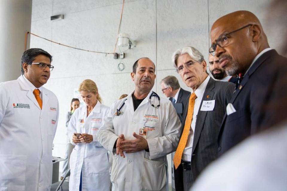 In July 2020, the University of Miami President Julio Frenk, in orange tie, confers with, from left, Drs. Dipen Parekh, Tanira Ferreira, David Lang, UHealth Emergency Manager Vincent Torres, back right, and UM Miller School of Medicine Dean Henri Ford, right, on the medical campus as they discuss the surge during the coronavirus pandemic.