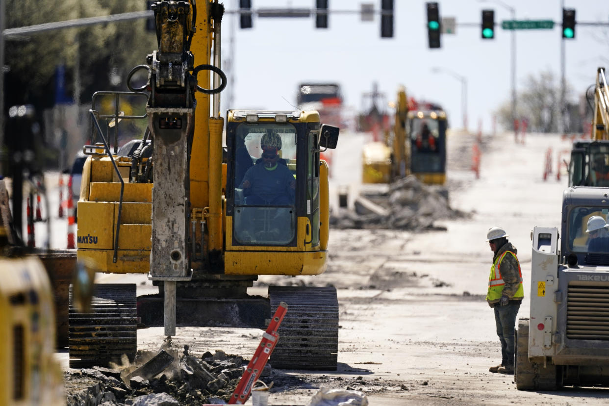 Workers toil on a project to replace old water lines under Main Street as part of work to update water and sewer systems as well as prepare the road for the expansion of a street car line in Kansas City, Mo. Wednesday, March 30, 2021. Looking beyond the $1.9 trillion COVID relief bill, President Joe Biden and lawmakers are laying the groundwork for another of his top legislative priorities with a long-sought boost to the nation's roads, bridges and other infrastructure that could meet GOP resistance to a hefty price tag. (AP Photo/Charlie Riedel)