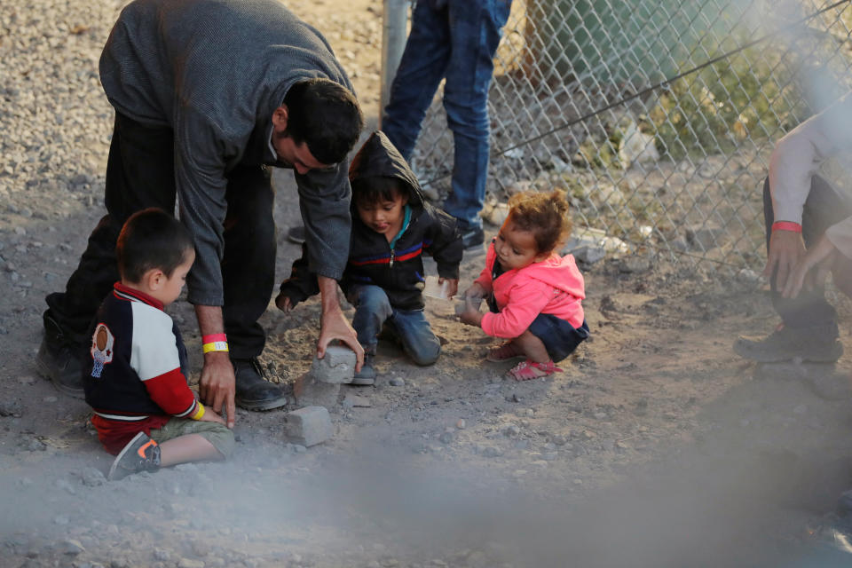 A man plays gives children rocks to play with inside an enclosure, where they are being held by U.S. Customs and Border Protection (CBP), after crossing the border between Mexico and the United States illegally and turning themselves in to request asylum, in El Paso, Texas, U.S., March 29, 2019. Photo: Lucas Jackson/Reuters)