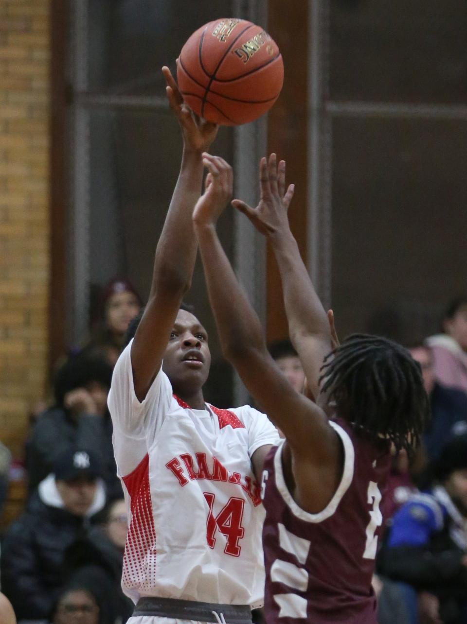 Franklin's Clarence Thompson puts in a short jumper over Aquinas's Christian McCullough.