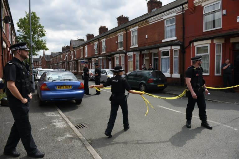 Police set a cordon outside a house in Manchester's Moss Side area on Saturday. Some local residents were evacuated and others were told to stay indoors