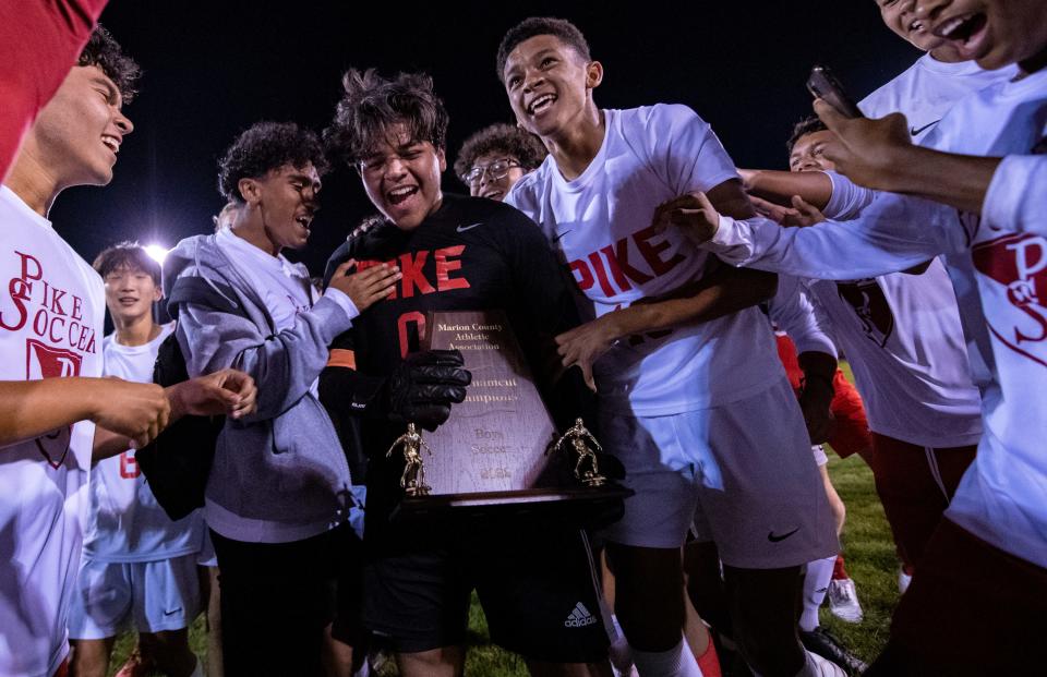 Pike High School senior Cesar Morales-Juarez (0) and his teammates celebrate after winning a Marion County Boys’ Soccer championship game against North Central High School, Saturday, Sept. 24, 2022, at North Central High School. Pike won 5-4 after penalty kicks.