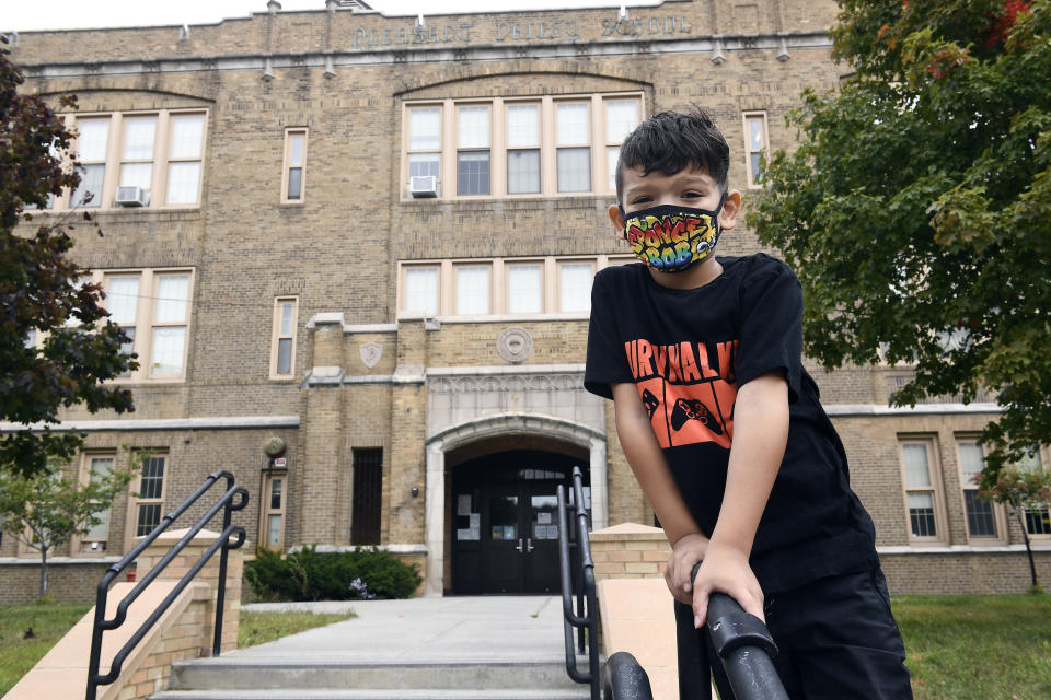 Second grade student Mason Negron, 6, whose mother Kristina Negron was laid off from her job as an aide for a special education class at Schenectady High School, due to budget cuts, poses for a photograph at his Pleasant Valley Elementary school Tuesday, Sept. 29, 2020, in Schenectady, N.Y. (AP Photo/Hans Pennink)