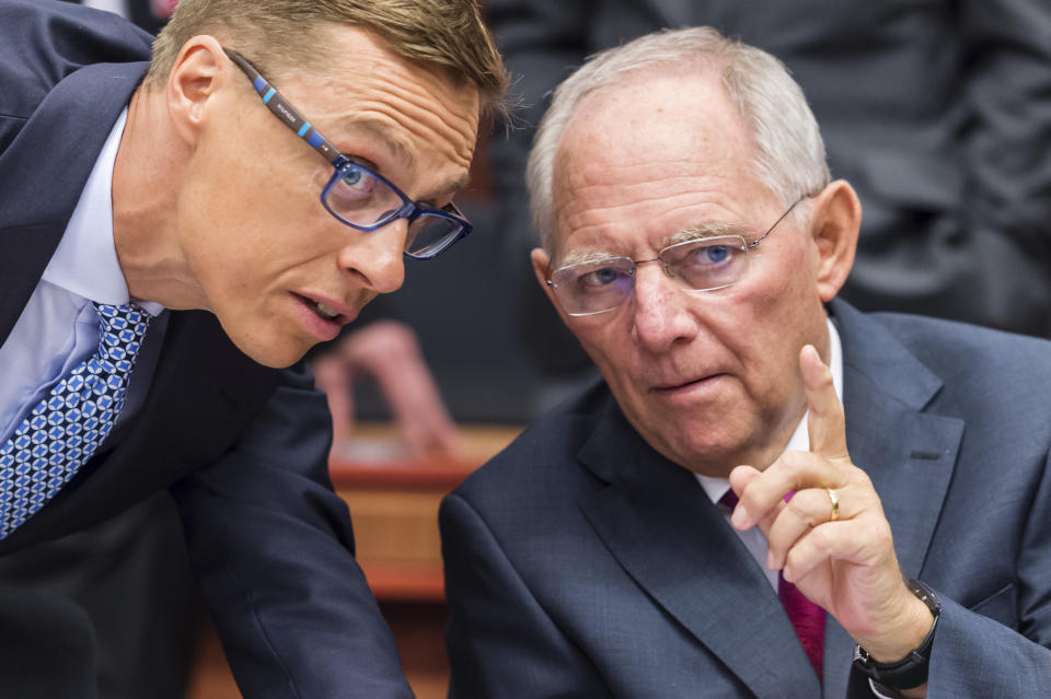 FILE - German Finance Minister Wolfgang Schaeuble, right, talks with Finnish Finance Minister Alexander Stubb during a meeting of eurogroup finance ministers at the EU Council building in Brussels on Monday, July 13, 2015. Wolfgang Schaeuble, who helped negotiate German reunification in 1990 and as finance minister was a central figure in the austerity-heavy effort to drag Europe out of its debt crisis more than two decades later, has died on Tuesday, Dec. 26, 2023. He was 81. (AP Photo/Geert Vanden Wijngaert, File)