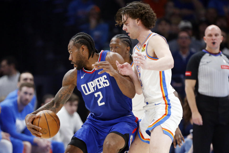 Los Angeles Clippers forward Kawhi Leonard (2) spins away from Oklahoma City Thunder guard Josh Giddey, right, during the first half of an NBA basketball game, Thursday, Feb. 22, 2024, in Oklahoma City. (AP Photo/Nate Billings)