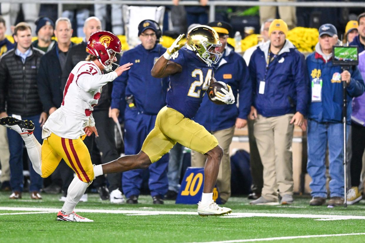Oct 14, 2023; South Bend, Indiana, USA; USC Trojans kicker Eddie Czaplicki (37) attempts to tackle Notre Dame Fighting Irish running back Jadarian Price (24) as he returns a kickoff for a touchdown in the fourth quarter at Notre Dame Stadium. Mandatory Credit: Matt Cashore-USA TODAY Sports