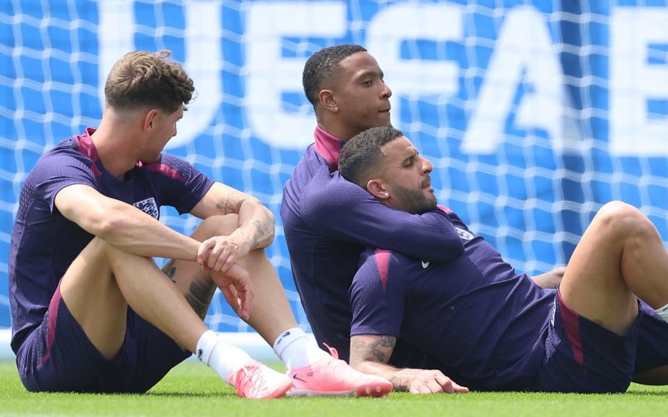 John Stones, Ezri Konsa and Kyle Walker sitting on the ground at training