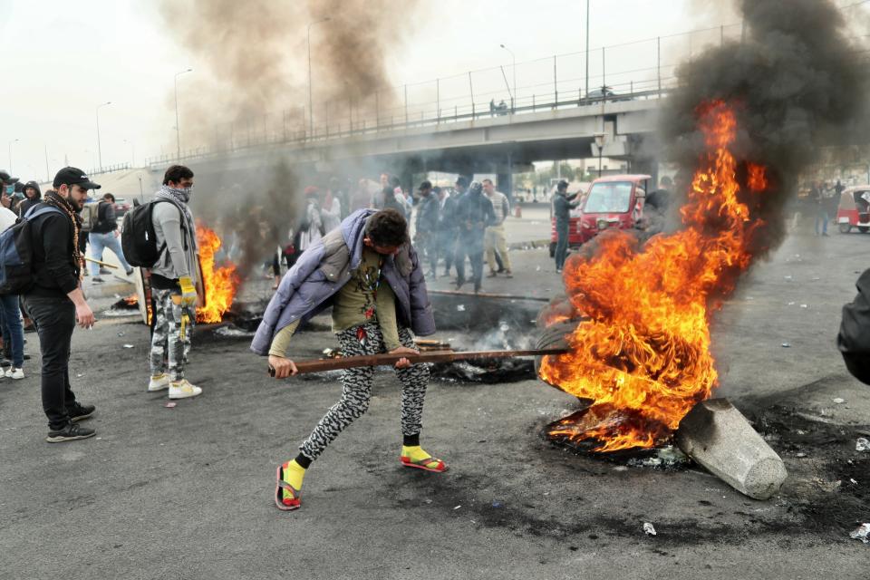 Anti-government protesters set fires and close streets during ongoing protests in downtown Baghdad, Iraq, Sunday, Jan. 19, 2020. Black smoke filled the air as protesters burned tires to block main roads in the Iraqi capital Baghdad, expressing their anger at poor services and shortages despite religious and political leaders calling for calm. (AP Photo/Hadi Mizban)