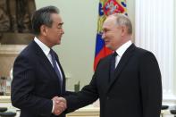 Russian President Vladimir Putin greets Chinese Communist Party's foreign policy chief Wang Yi during their meeting at the Kremlin in Moscow, Russia, Wednesday, Feb. 22, 2023. (Anton Novoderezhkin, Sputnik, Kremlin Pool Photo via AP)