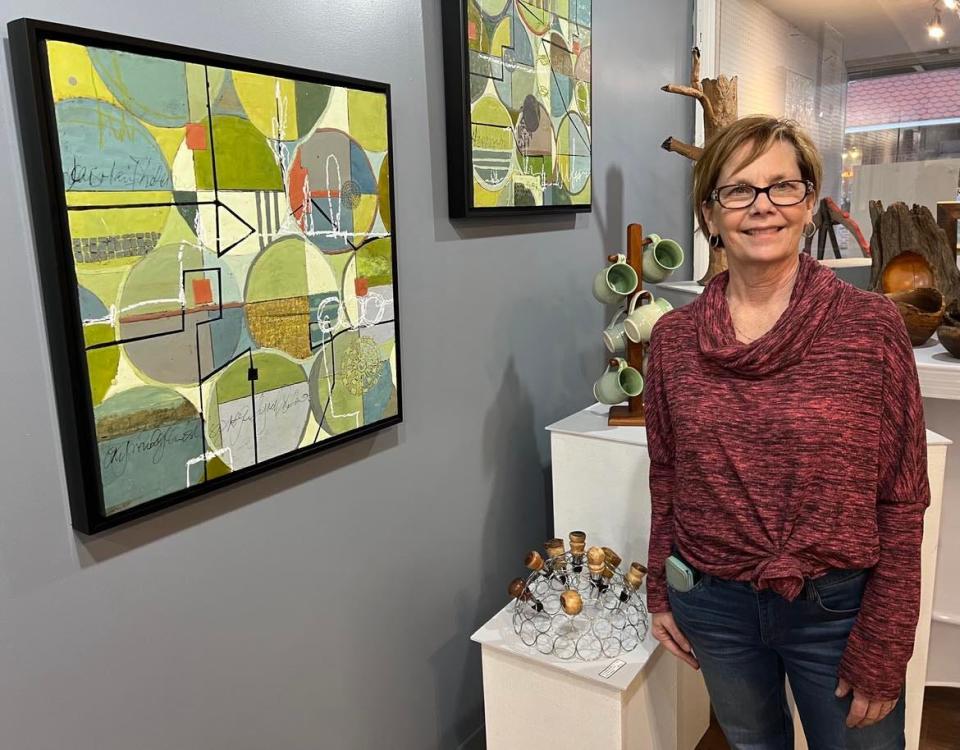Therese Cook, resident artist at Market Street Art Spot in downtown Minerva, is shown with her artwork at the relocated and expanded gallery, which will hold a grand re-opening event from 5 to 9 p.m. Friday.
