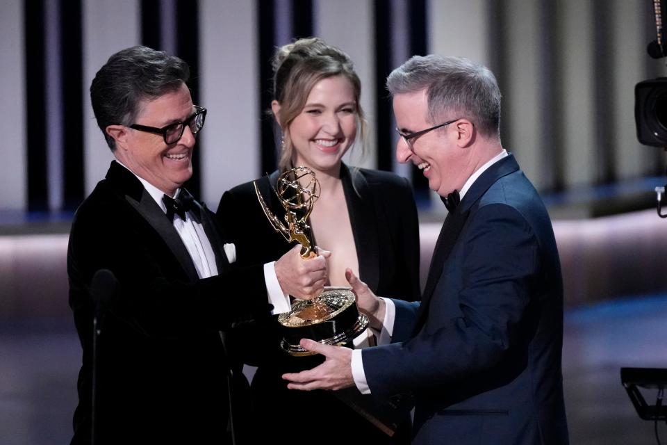 Stephen Colbert and Taylor Tomlinson present John Oliver with the award for outstanding scripted variety series during the 75th Emmy Awards at the Peacock Theater in Los Angeles on Monday, Jan. 15, 2024.