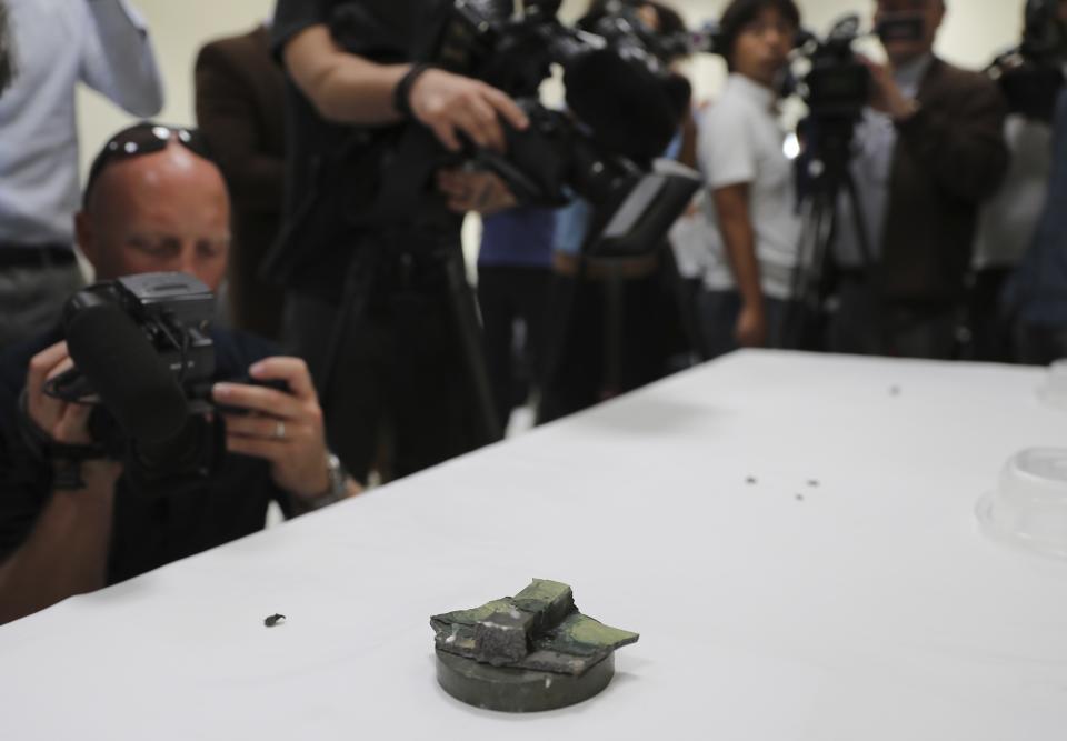 Journalists take pictures of a magnet the U.S. Navy says came from a limpet mine that didn't explode on a Japanese-owned oil tanker at a 5th Fleet base, during a trip organized by the Navy for journalists, near Fujairah, United Arab Emirates, Wednesday, June 19, 2019. (AP Photo/Kamran Jebreili)