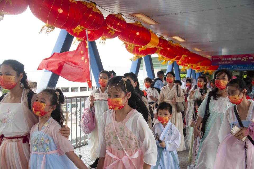 Children wave national flags as they move along the harbor in Hong Kong on Friday.  (Mithil Aggarwal / NBC News)