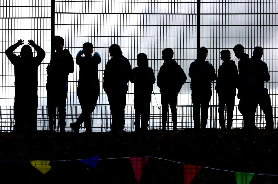 <p>School children wait for the arrival of the Prince of Wales and the Duchess of Cornwall to Bangor Market where they walked around and meeting stall holders at the open-air market. Picture date: Wednesday May 19, 2021.</p>
