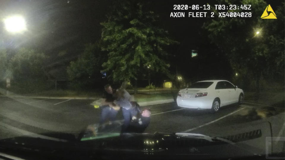 This screen grab taken from dashboard camera video provided by the Atlanta Police Department shows Rayshard Brooks, center, struggling with Officers Garrett Rolfe, left, and Devin Brosnan in the parking lot of a Wendy's restaurant, early Saturday, June 13, 2020, in Atlanta. Rolfe has been fired following the fatal shooting of Brooks and Brosnan has been placed on administrative duty. (Atlanta Police Department via AP)