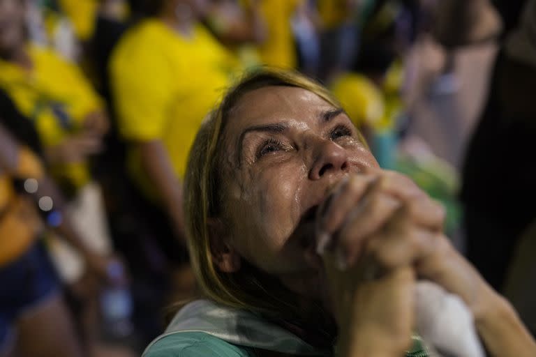 
Una simpatizante de Jair Bolsonaro sostiene sus manos en oración mientras observa los resultados parciales luego del cierre de las urnas en la segunda vuelta de las elecciones presidenciales en Río de Janeiro, Brasil, el domingo 30 de octubre de 2022.