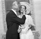 <p>Dorothy Dandridge receives a kiss from her husband outside of Los Angeles's St. Sophia Orthodox Cathedral following their ceremony. For her wedding to the restaurant owner, Dandridge wore a chiffon gown with bishop sleeves and a sheer wide-brimmed hat. </p>