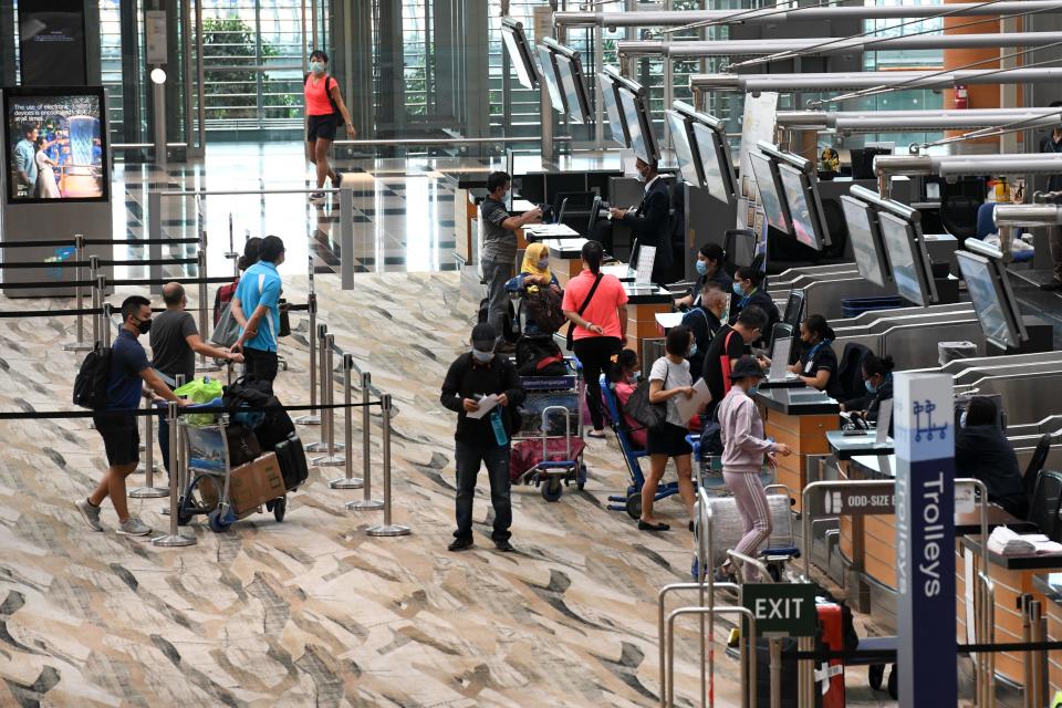 Passengers queue at a check-in counter at Changi International Airport in Singapore on June 8, 2020, as Singapore prepares to reopen its borders after shutting them to curb the spread of the COVID-19 novel coronavirus. (Photo by Roslan RAHMAN / AFP) (Photo by ROSLAN RAHMAN/AFP via Getty Images)