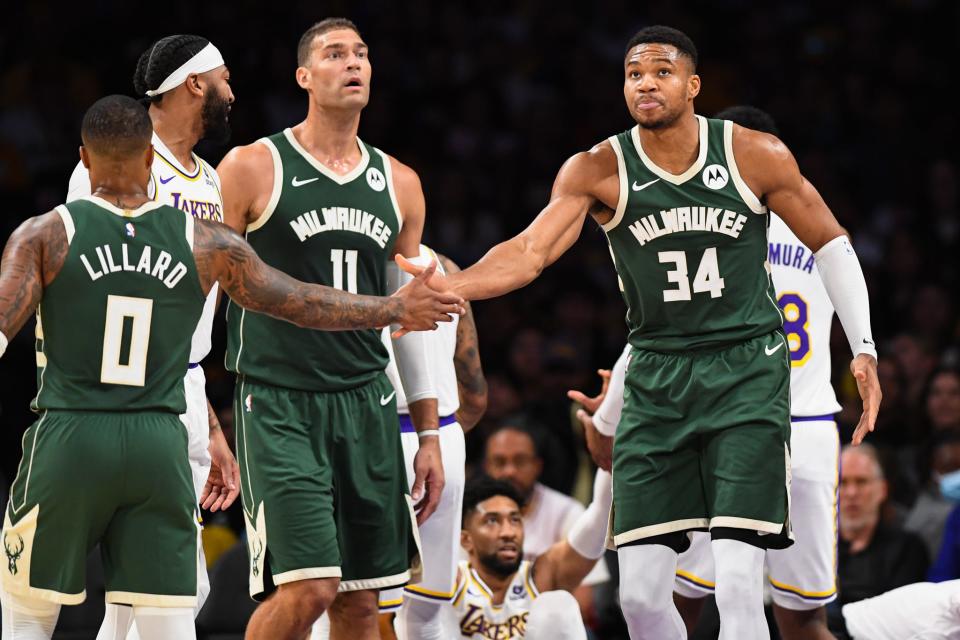 Milwaukee Bucks forward Giannis Antetokounmpo celebrates with guard Damian Lillard and center Brook Lopez in a preseason game against the Los Angeles Lakers on Oct. 15, 2023 in Los Angeles.