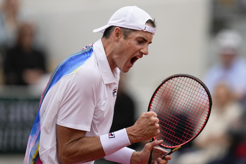 John Isner of the U.S. clenches his fist after scoring a point against France's Quentin Halys during their first round match at the French Open tennis tournament in Roland Garros stadium in Paris, France, Sunday, May 22, 2022. (AP Photo/Michel Euler)