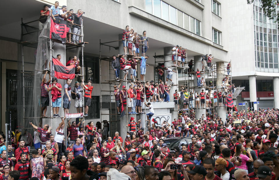 Fans of Brazil's Flamengo watch the team victory parade at their arrival in Rio de Janeiro, Brazil, Sunday, Nov. 24, 2019. Flamengo overcame Argentina's River Plate 2-1 in the Copa Libertadores final match on Saturday in Lima to win its second South American title. (AP Photo/Ricardo Borges)