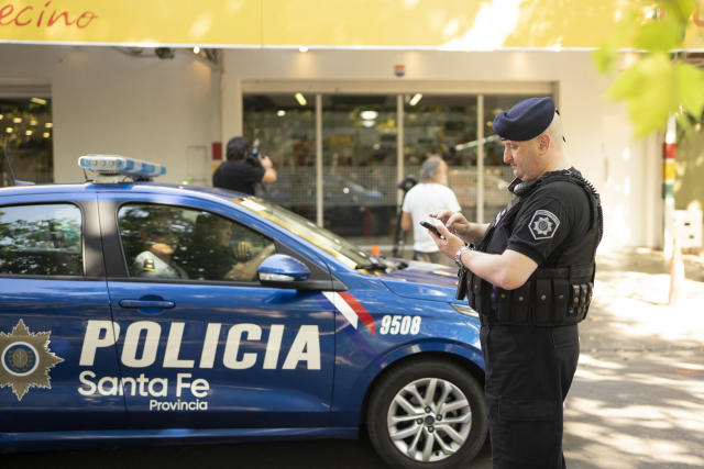 Police gather outside the Unico supermarket, a grocery chain owned by soccer player Lionel Messi's in-laws, after it was shot at in Rosario, Argentina, Thursday, March 2, 2023. (AP Photo/Sebastian Lopez Brach)