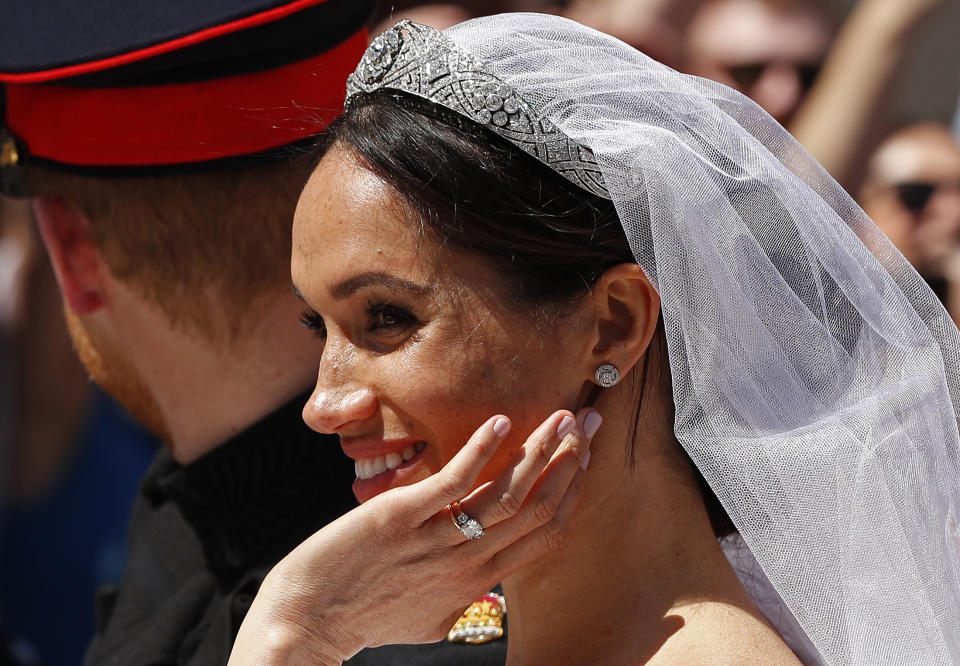 Meghan, Duchess of Sussex reacts from the Ascot Landau Carriage during the carriage procession with Britain's Prince Harry, Duke of Sussex on the High Street in Windsor, on May 19, 2018 after their wedding ceremony. (Photo by JOHN SIBLEY / POOL / AFP)        (Photo credit should read JOHN SIBLEY/AFP via Getty Images)