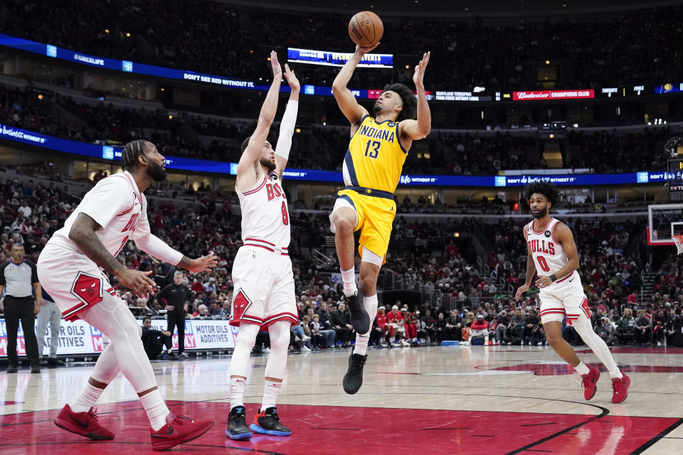 Indiana Pacers forward Jordan Nwora (13) drives to the basket as Chicago Bulls center Andre Drummond, left, guard Zach LaVine, second from left, guard during the first half of an NBA basketball game in Chicago, Sunday, March 5, 2023. (AP Photo/Nam Y. Huh)