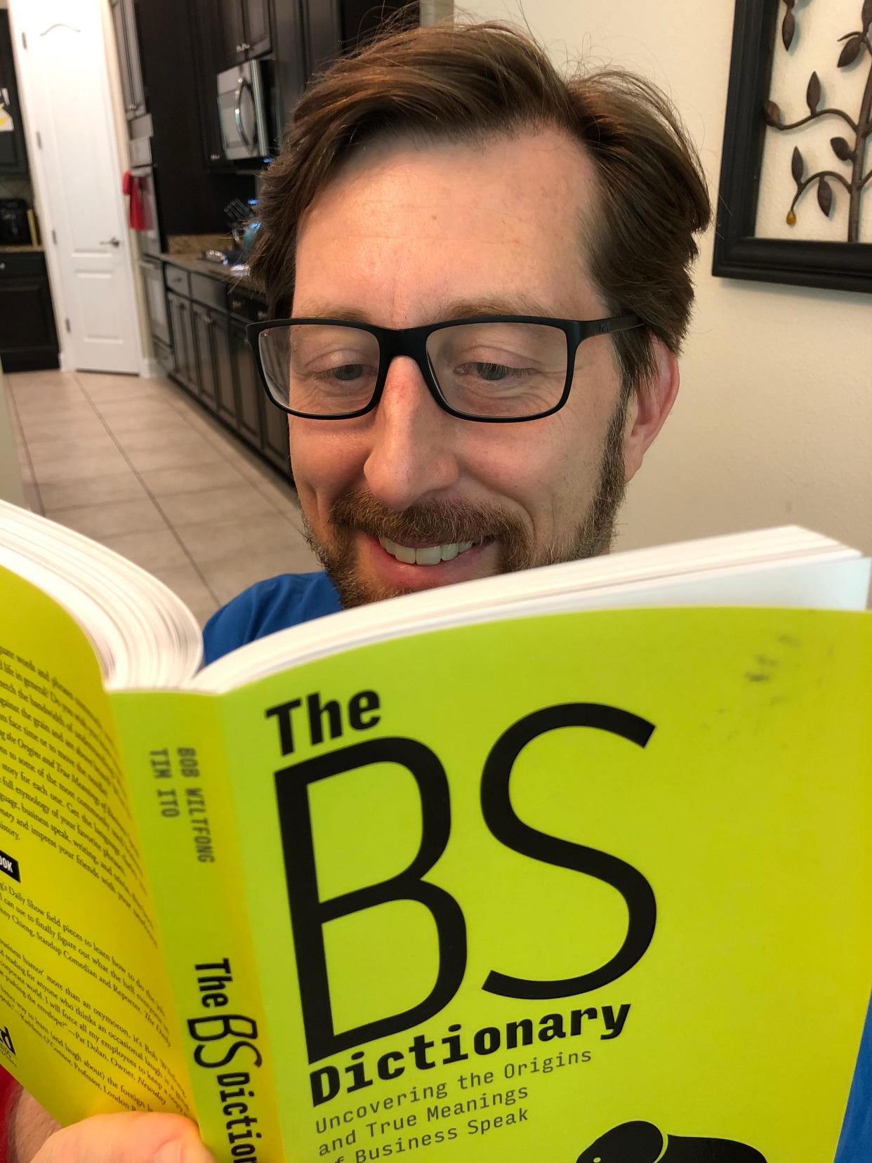 Bob Wiltfong reading a copy of his book, "The BS Dictionary."