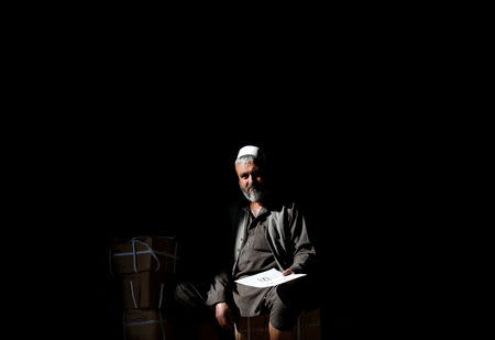 An Afghan election commission worker counts ballot boxes and election material in a warehouse in Kabul, Afghanistan October 18, 2018.REUTERS/Mohammad Ismail