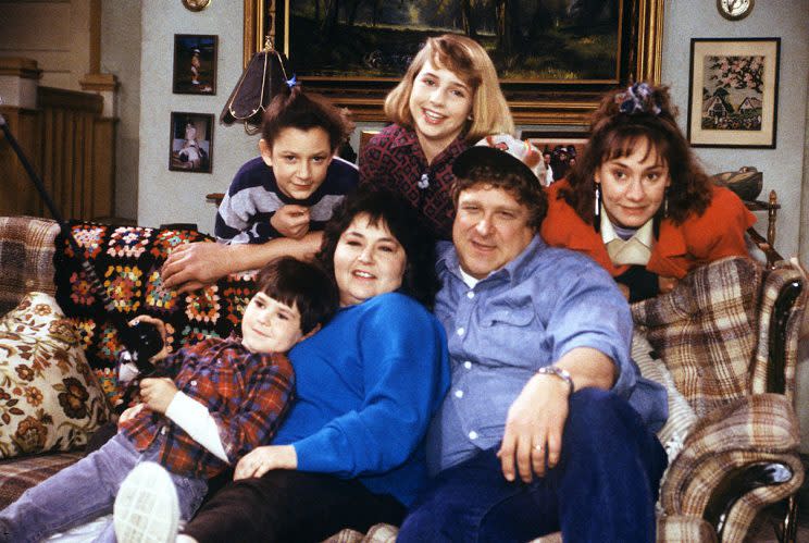 The cast of Roseanne on a couch, in a promotional photo.