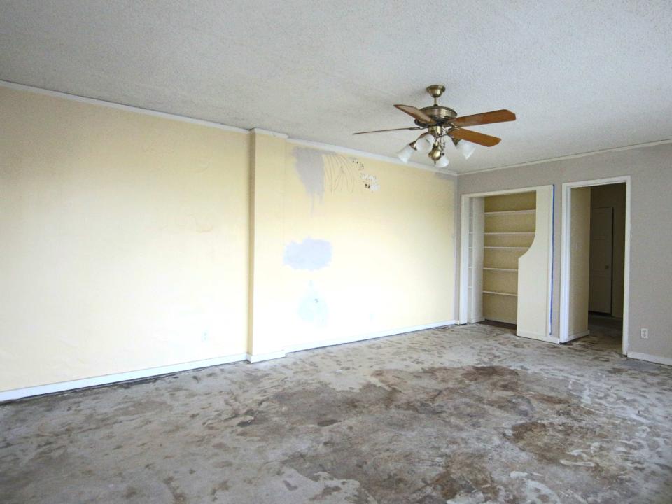 An empty, rundown room. Paint is peeling off the walls and the floor is dirty.