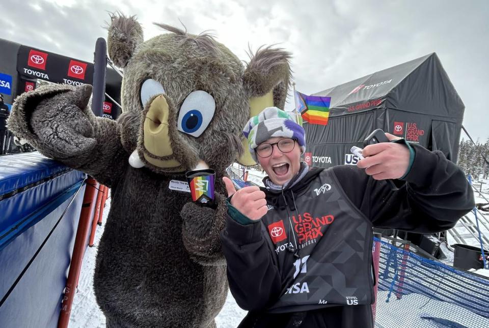 Riccomini poses with an LGBTQ pride flag tucked into his beanie.