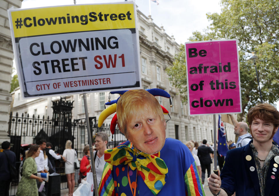 A protestor with a mask of Britain's Prime Minister Boris Johnson demonstrates outside Downing Street in London, Wednesday, Aug. 28, 2019. Prime Minister Johnson has written to fellow lawmakers explaining his decision to ask Queen Elizabeth II to suspend Parliament as part of the government plans before the Brexit split from Europe. (AP Photo/Frank Augstein)