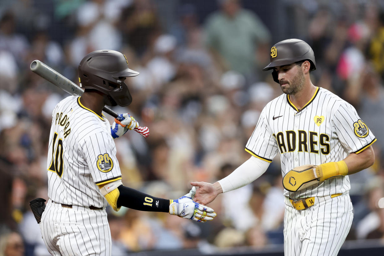 San Diego Padres' Tyler Wade, right, is greeted by Jurickson Profar, left, after scoring off a single hit by designated hitter Luis Arraez during the fifth inning of a baseball game against the San Francisco Giants, Saturday, Sept. 7, 2024, in San Diego. (AP Photo/Ryan Sun)