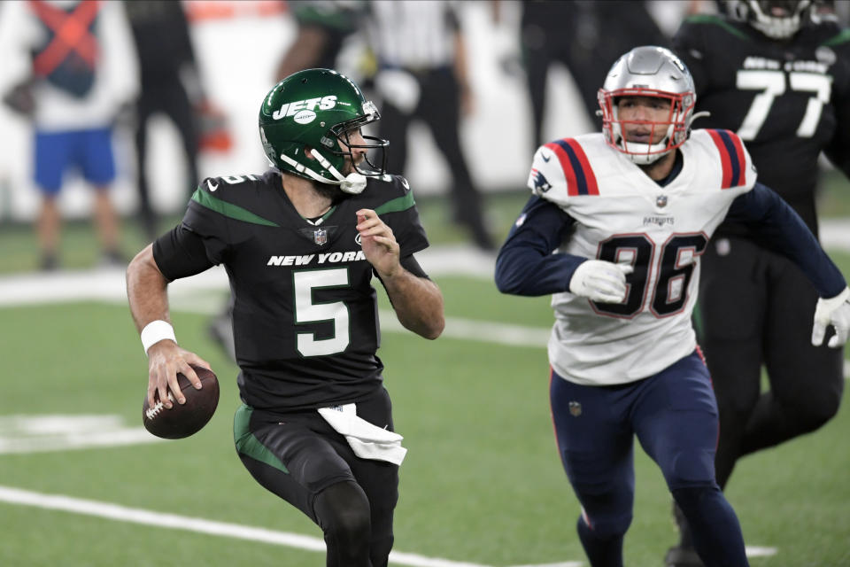 New York Jets quarterback Joe Flacco, left, looks to throw during the first half of an NFL football game against the New England Patriots, Monday, Nov. 9, 2020, in East Rutherford, N.J. (AP Photo/Bill Kostroun)