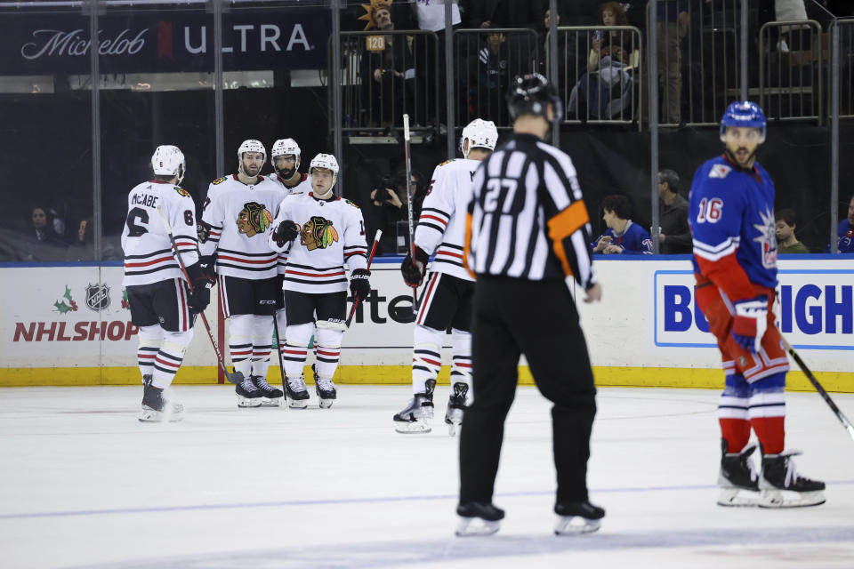 Chicago Blackhawks center Max Domi (13) celebrates with teammates after scoring a goal as New York Rangers center Vincent Trocheck (16) interacts with referee Eric Furlatt (27) during the third period of an NHL hockey game, Saturday, Dec. 3, 2022, in New York. (AP Photo/Jessie Alcheh)