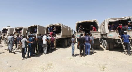 Shi'ite volunteers, who have joined the Iraqi army to fight against militants of the Islamic State, formerly known as the Islamic State in Iraq and the Levant (ISIL), climb into trucks in Baghdad July 9, 2014. REUTERS/Ahmed Saad